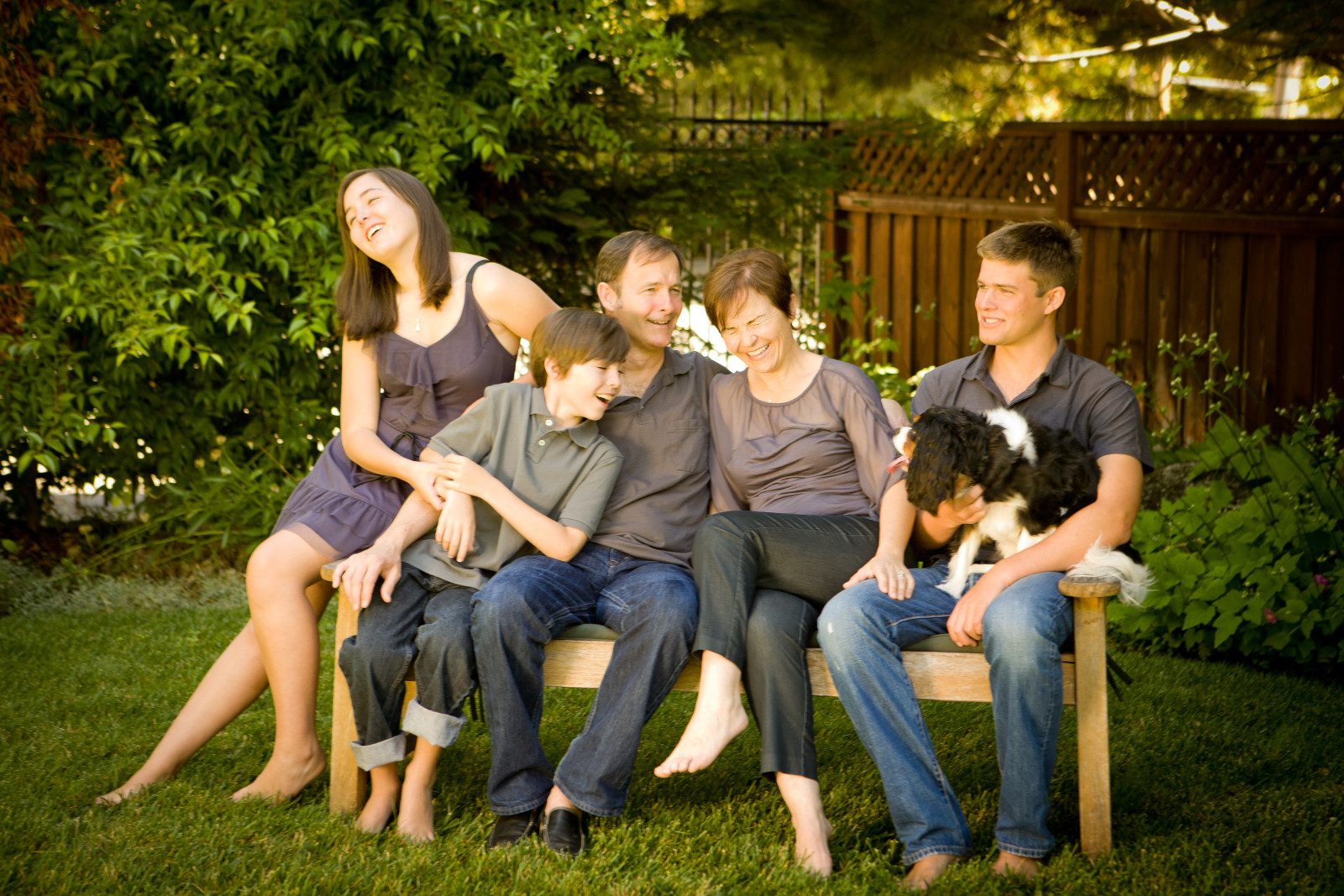 A family sitting on a bench in a garden