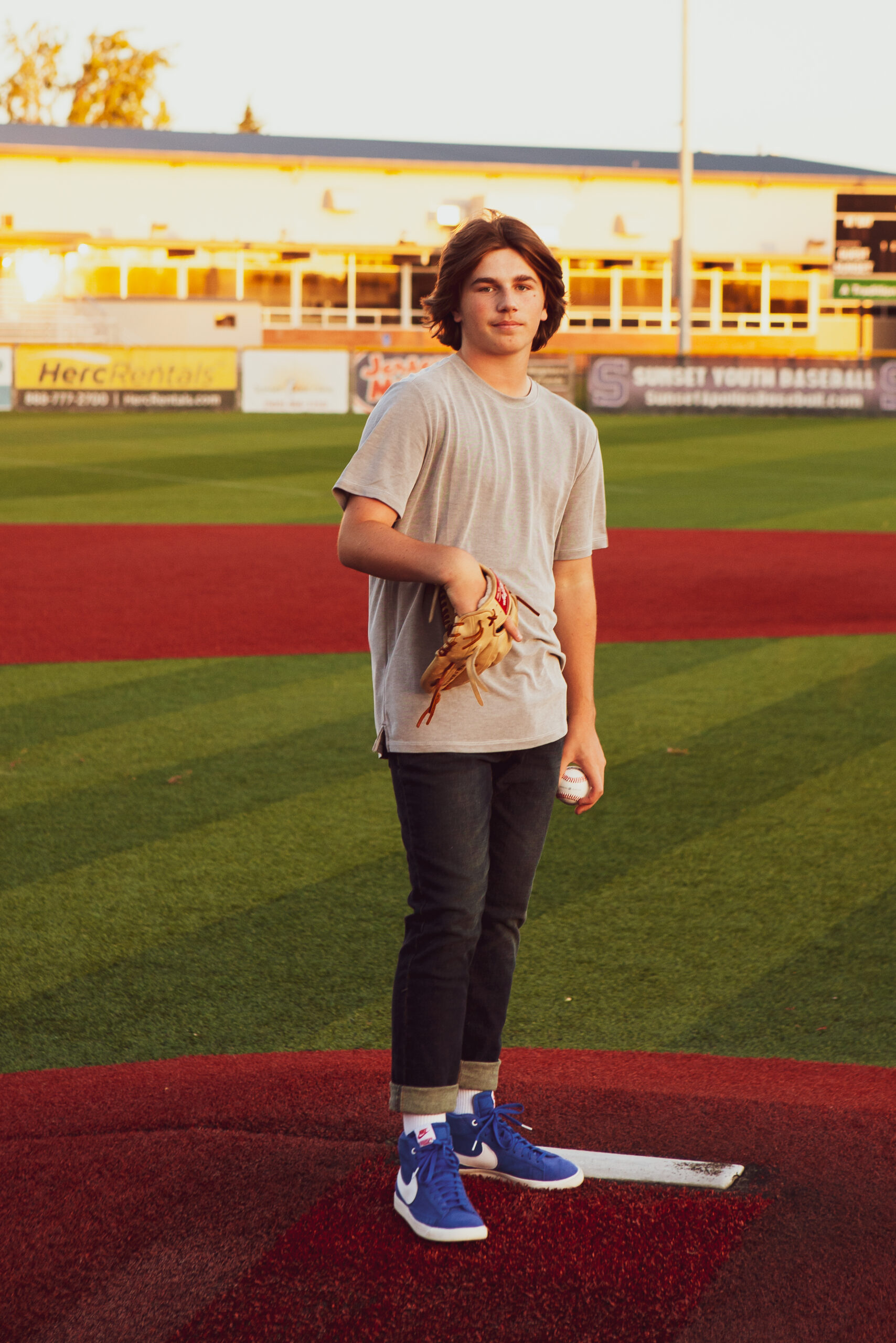 A man standing on top of a baseball field holding a ball.