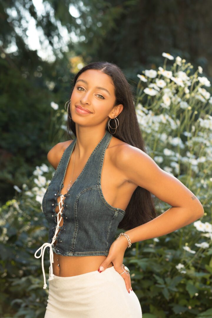 A woman in a denim halter top posing for the camera.