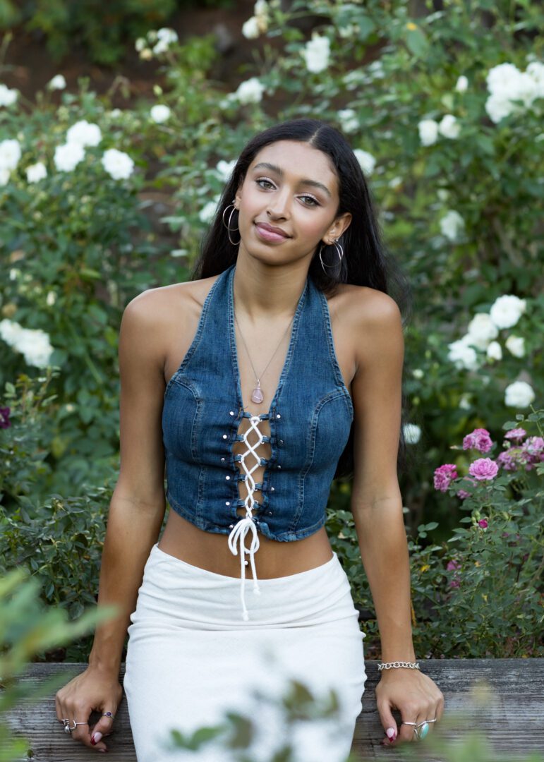 A woman in white shorts and a denim halter top.