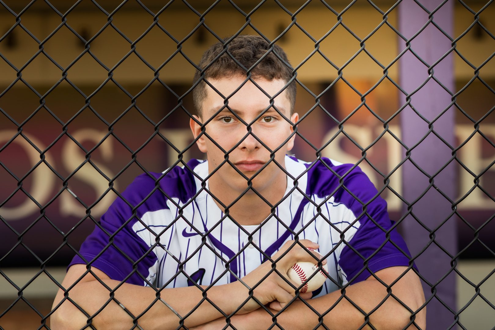 A baseball player is sitting in the dugout.