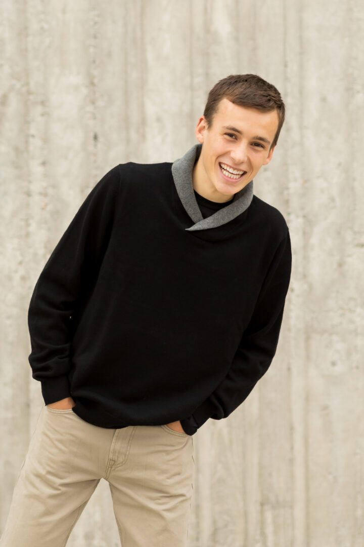 A man in black sweater smiling for the camera.