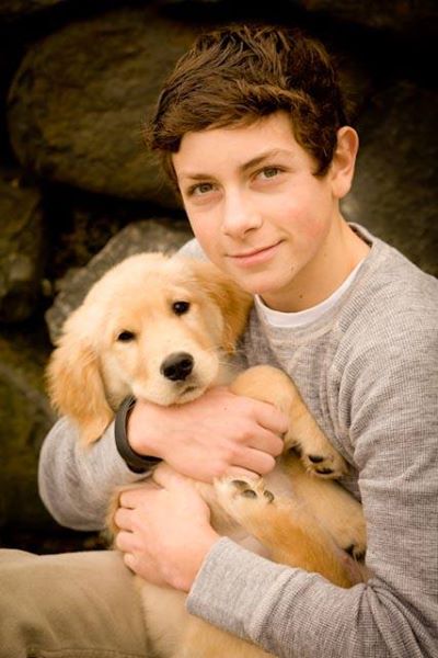A boy holding his dog in his arms.