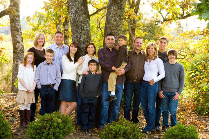 A large family posing for a picture in the woods.