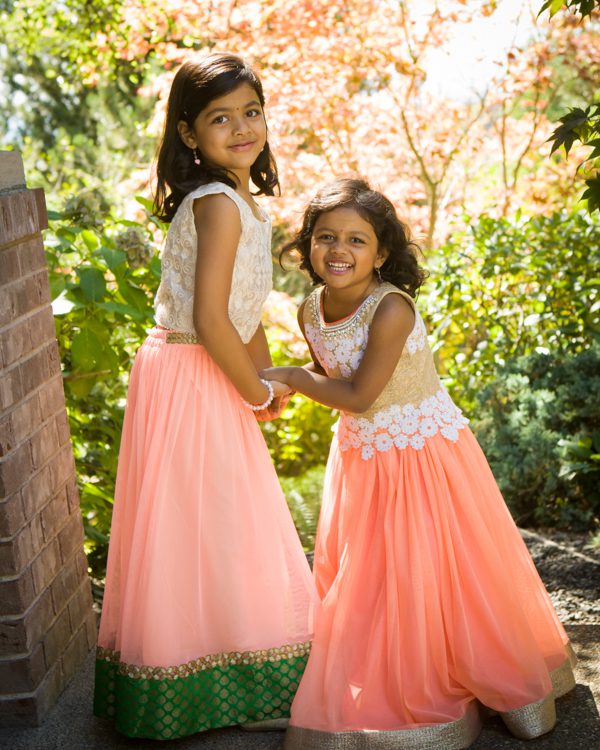 Two girls in pink dresses posing for a picture.